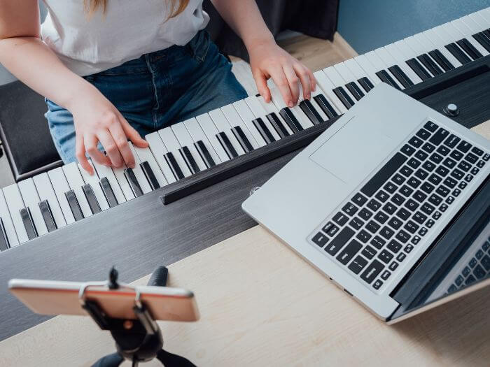 piano lesson conducted online with laptop and iphone on tripod